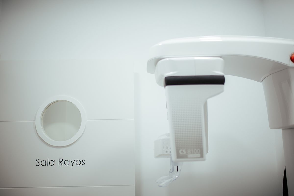 Equipo de radiografía panorámica junto a la puerta de la sala de rayos