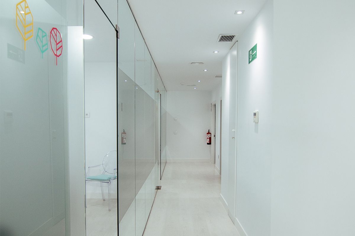 Pasillo con gabinetes acristalados y los árboles del logotipo en el cristal